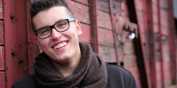young man with glasses smiling
